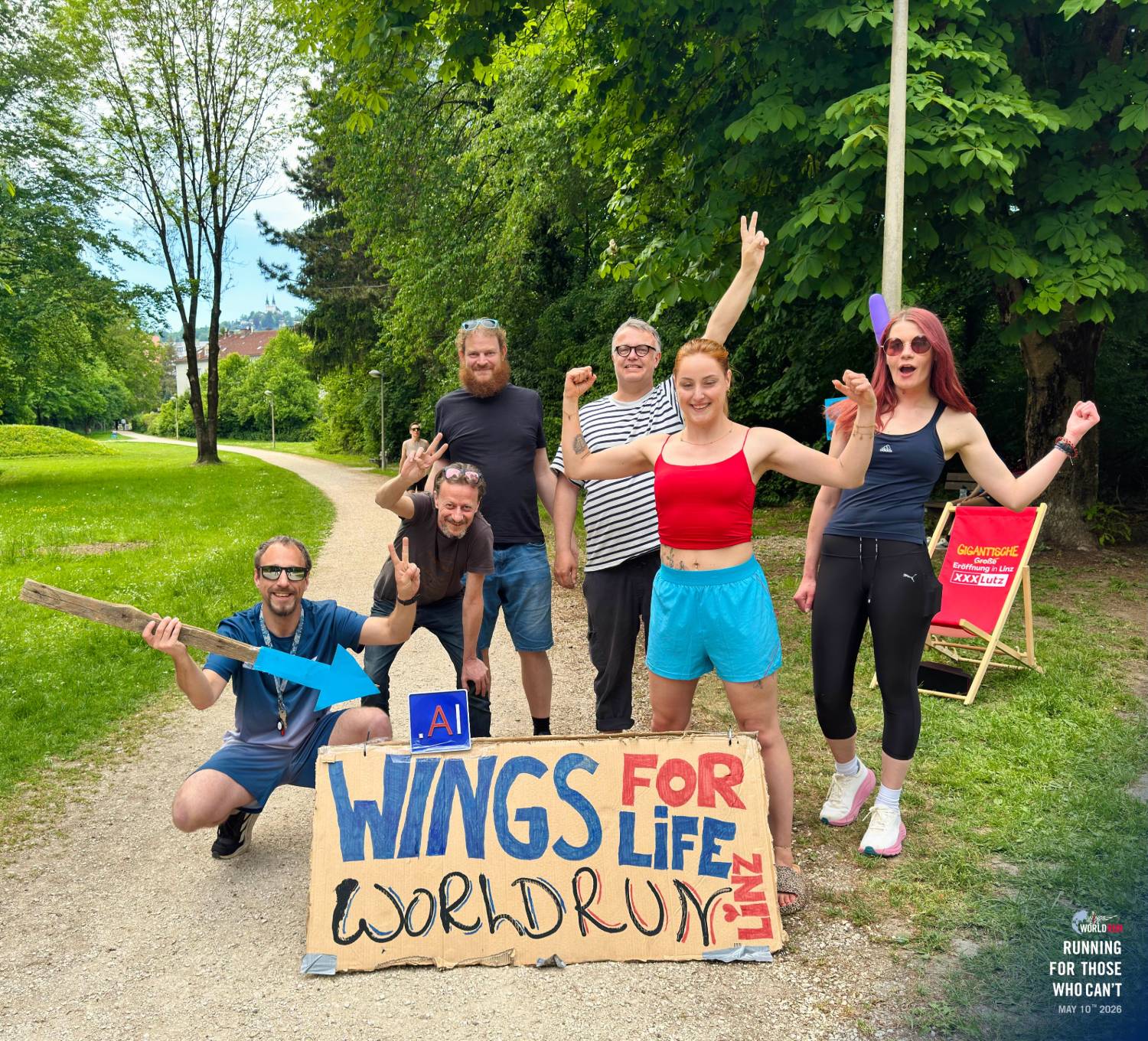 Wings For Life Worldrun Linz – Team mit selbstgemaltem Schild im Heilhamerpark